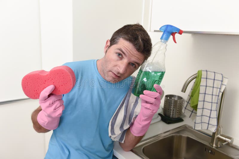 Młody gnuśny domowy cleaner mężczyzna domycie i cleaning kuchnia męczył w stresie obraz royalty free Młody gnuśny domowy cleaner mężczyzna domycie i cleaning kuchnia męczył w stresie obraz royalty free