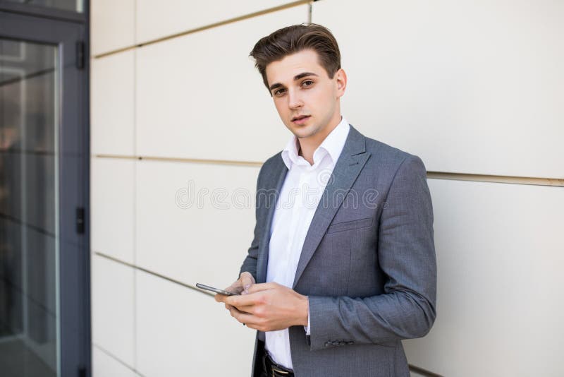 Młody miastowy fachowy mężczyzna używa mądrze telefon w budynku biurowym indoors Biznesmena mienia mobilny smartphone używać app obrazy stock Młody miastowy fachowy mężczyzna używa mądrze telefon w budynku biurowym indoors Biznesmena mienia mobilny smartphone używać app obrazy stock