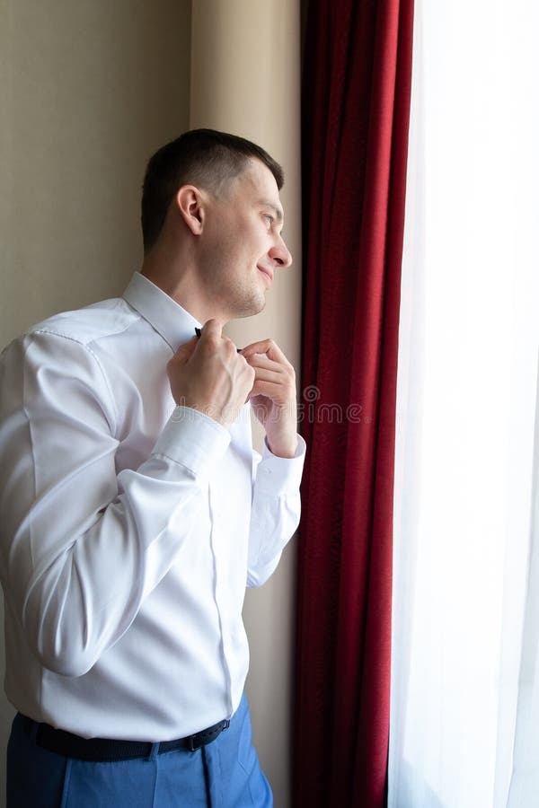 Młody mąż idzie na ceremonię ślubną w luksusowym hotelu w niebieskim garniturze i dostosowuje krawat łuku podczas oczekiwania obrazy royalty free Młody mąż idzie na ceremonię ślubną w luksusowym hotelu w niebieskim garniturze i dostosowuje krawat łuku podczas oczekiwania obrazy royalty free