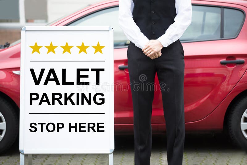 Młody Męski lokaj Stoi Blisko ostawianie samochodu na parking przez obsługę znaka zdjęcia royalty free Młody Męski lokaj Stoi Blisko ostawianie samochodu na parking przez obsługę znaka zdjęcia royalty free
