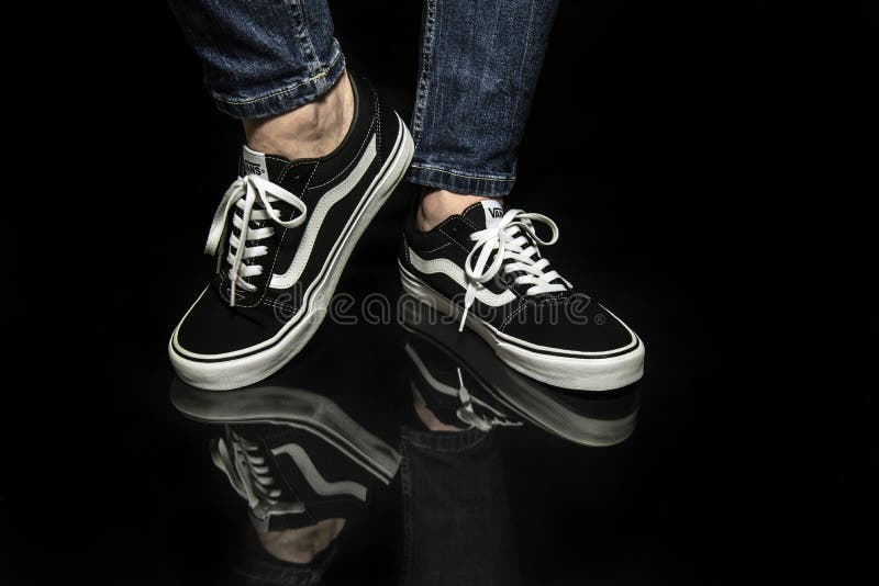 Młody mężczyzna noszący nowe czarno-białe buty Vans Old Skool zdjęcie stock Młody mężczyzna noszący nowe czarno-białe buty Vans Old Skool zdjęcie stock
