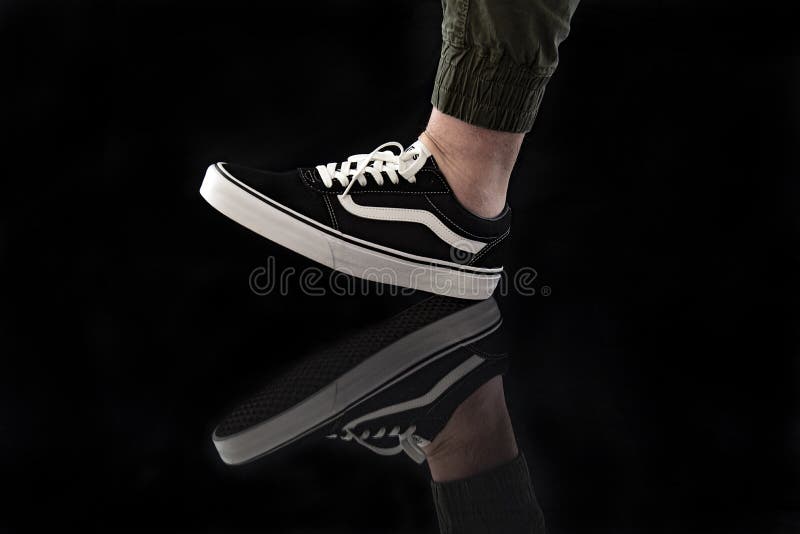 Młody mężczyzna noszący nowe czarno-białe buty Vans Old Skool obrazy stock Młody mężczyzna noszący nowe czarno-białe buty Vans Old Skool obrazy stock