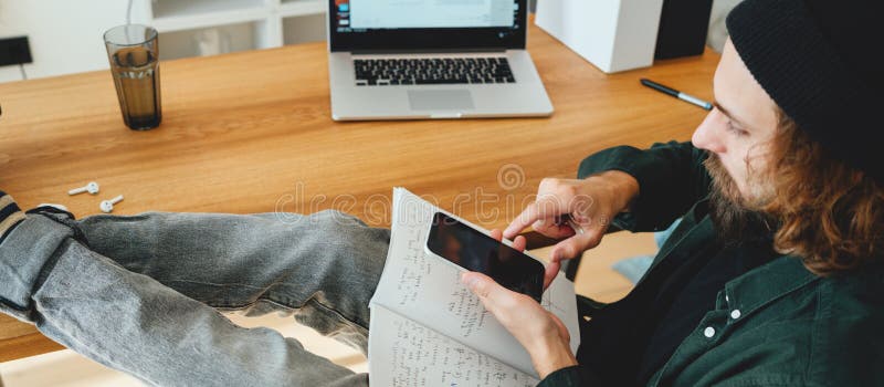 Młody mężczyzna robi notatki podczas nauki online. obraz szeroki zdjęcia stock