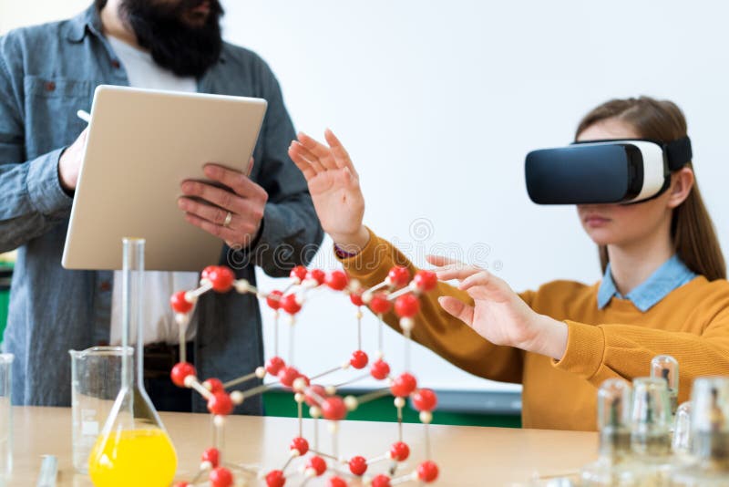Młody nauczyciel używa rzeczywistość wirtualna szkła i 3D prezentację uczyć uczni w chemii klasie Edukacja, VR, nauczanie