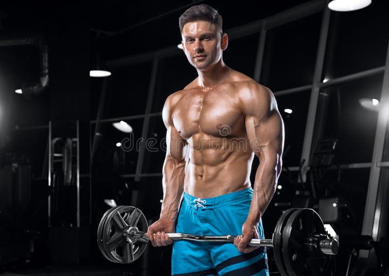 Młody przystojny facet robi ćwiczeniom w gym fotografia stock Młody przystojny facet robi ćwiczeniom w gym fotografia stock