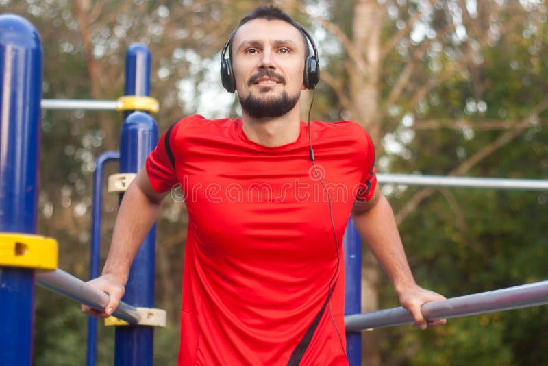 Młody sportowy mężczyzna robi sportowi ćwiczy outdoors w parku fotografia stock Młody sportowy mężczyzna robi sportowi ćwiczy outdoors w parku fotografia stock