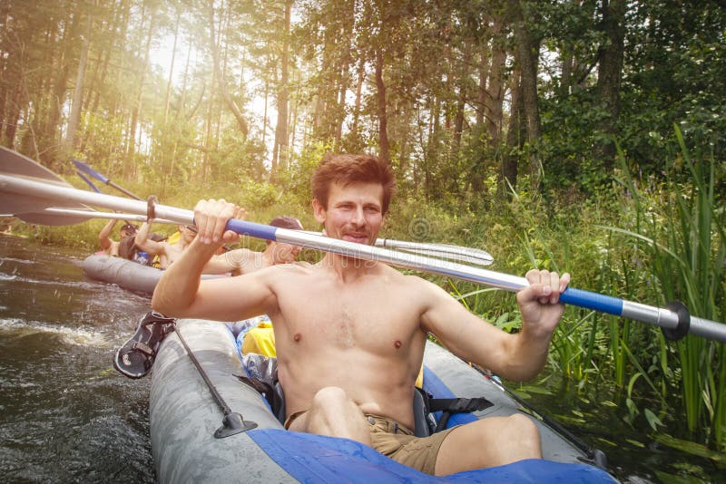 Młody sporty mężczyzna w kajaku z wiosłem Kajakować na rzece podczas lato sezonu obraz royalty free Młody sporty mężczyzna w kajaku z wiosłem Kajakować na rzece podczas lato sezonu obraz royalty free