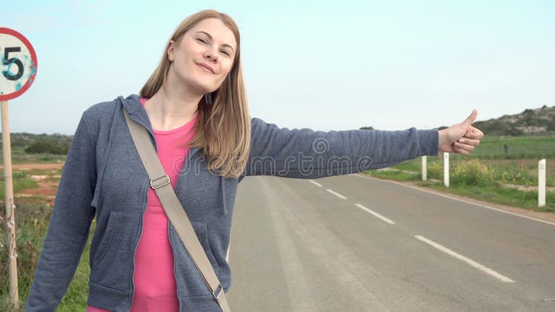 Młody szczęśliwy kobiety odprowadzenie wsi drogowy hitchhiking Patrzeć dla przejażdżki zaczynać podróż