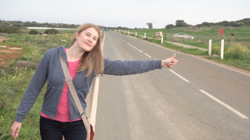 Młody szczęśliwy kobiety odprowadzenie wsi drogowy hitchhiking Patrzeć dla przejażdżki zaczynać podróż