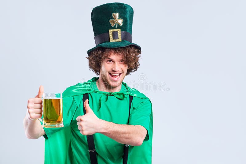 Młody z włosami mężczyzna w kostiumu St Patrick z kubkiem o obraz royalty free Młody z włosami mężczyzna w kostiumu St Patrick z kubkiem o obraz royalty free
