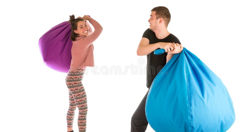 Młody śmieszny samiec i kobiety bój z beanbag krzesłami obraz royalty free Młody śmieszny samiec i kobiety bój z beanbag krzesłami obraz royalty free