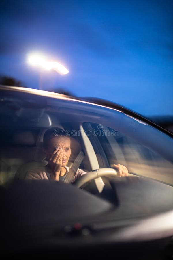 Young female driver at the wheel of her car, super tired, falling asleep while driving in a potentially dangerous situation - Road safety concept. Young female driver at the wheel of her car, super tired, falling asleep while driving in a potentially dangerous situation - Road safety concept