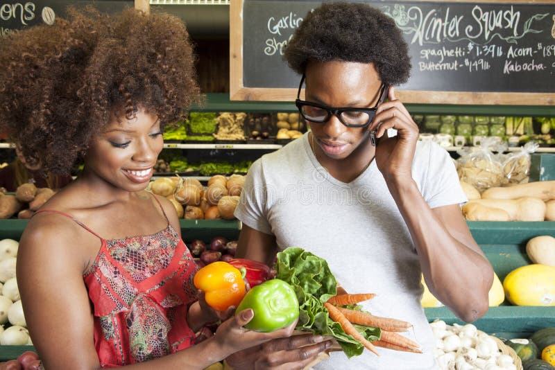Young African American couple buying vegetables at supermarket. Young African American couple buying vegetables at supermarket