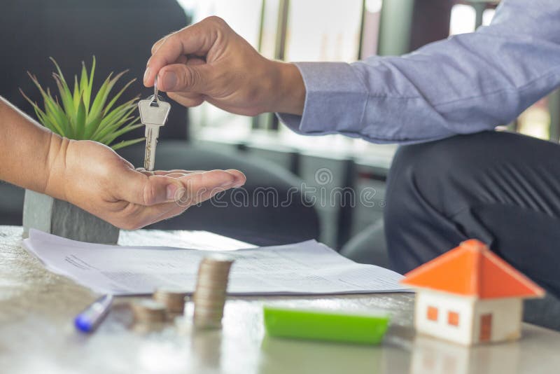 Młodzi człowiecy bierze klucze od męskiego agenta nieruchomości podczas spotkania obrazy stock Młodzi człowiecy bierze klucze od męskiego agenta nieruchomości podczas spotkania obrazy stock