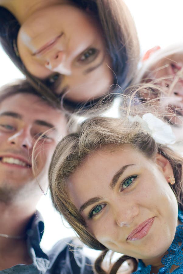 Head shot Portrait of beautiful young women surrounded by Happy smiling mixed group of Young people pretty girl and two handsome young men having fun outdoors. Head shot Portrait of beautiful young women surrounded by Happy smiling mixed group of Young people pretty girl and two handsome young men having fun outdoors