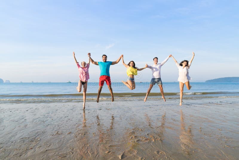 Young People Group Jump On Beach Summer Vacation, Happy Smiling Friends Sea Ocean Holiday Travel. Young People Group Jump On Beach Summer Vacation, Happy Smiling Friends Sea Ocean Holiday Travel