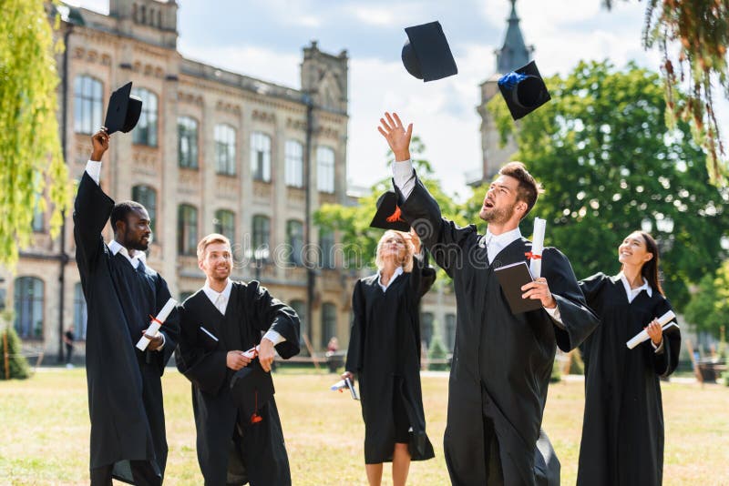 młodzi szczęśliwi kończący studia ucznie rzuca w górę skalowanie nakrętek zdjęcie royalty free młodzi szczęśliwi kończący studia ucznie rzuca w górę skalowanie nakrętek zdjęcie royalty free