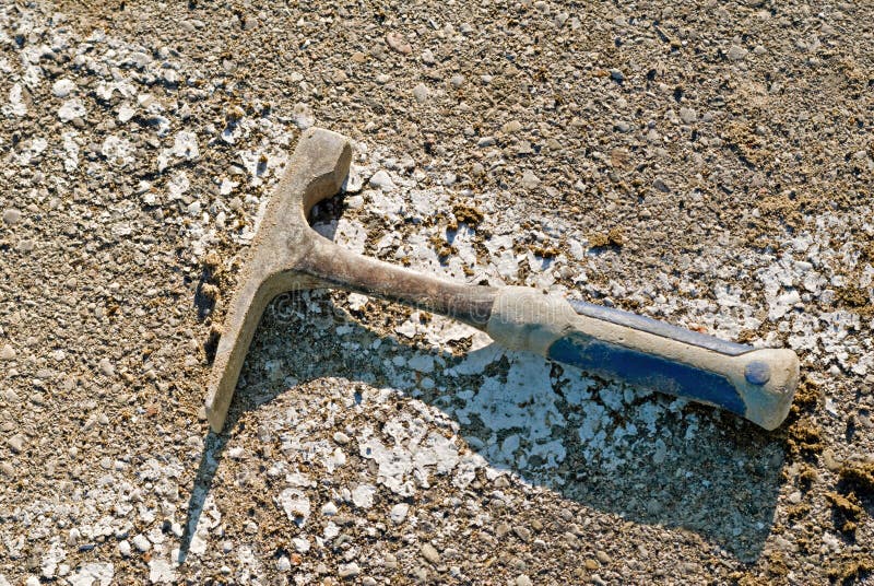 Geologists hammer lying on pavement. Geologists hammer lying on pavement.