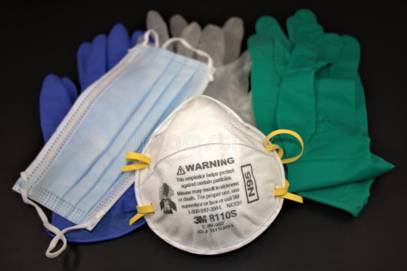 N95 Respirator, surgical procedure mask and pairs of different medical examination gloves. PPE or Personal Protective Equipment against black background. Top view, Abstract photo. N95 Respirator, surgical procedure mask and pairs of different medical examination gloves. PPE or Personal Protective Equipment against black background. Top view, Abstract photo