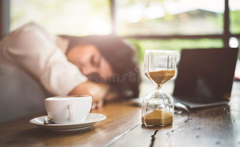 N? ra upp av sandglass med aff? rskvinnan som? r tr? tt fr? n att arbeta med bakgrund f? r b? rbar datordator Koppla av att sova, och t royaltyfri bild