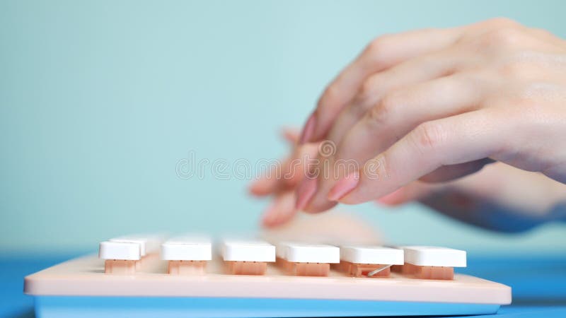 N?rbild Kvinnliga h?nder skriver p? ett rosa tangentbord, p? en bl? bakgrund arkivfoton N?rbild Kvinnliga h?nder skriver p? ett rosa tangentbord, p? en bl? bakgrund arkivfoton