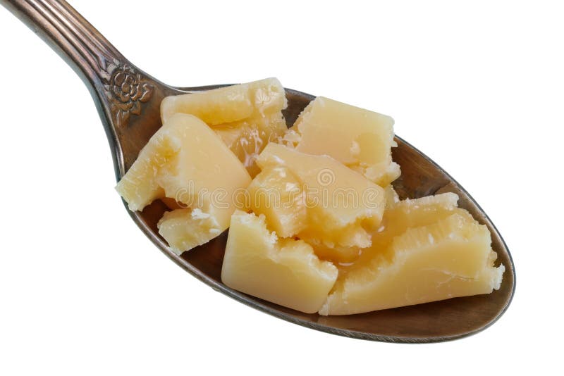 Na colher dourada velha há uma pilha pequena do alimento - partes de doces do leite condensado derretido com o mel e o creme isol fotografia de stock Na colher dourada velha há uma pilha pequena do alimento - partes de doces do leite condensado derretido com o mel e o creme isol fotografia de stock