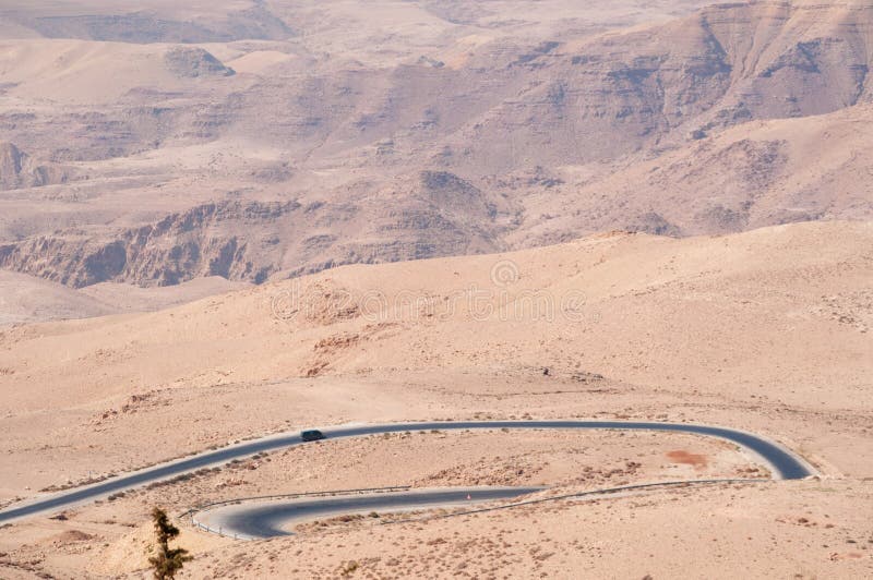 Jordan 05/10/2013: Jordanian and desert landscape with the winding road to Mount Nebo, an elevated ridge mentioned in the Hebrew Bible as the place where Moses was granted a view of the Promised Land. Jordan 05/10/2013: Jordanian and desert landscape with the winding road to Mount Nebo, an elevated ridge mentioned in the Hebrew Bible as the place where Moses was granted a view of the Promised Land