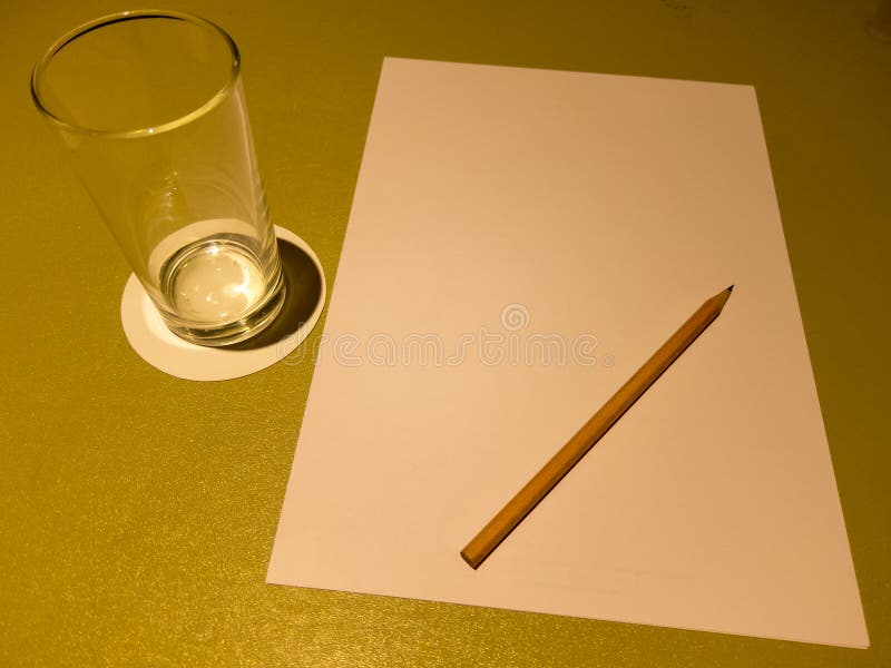 Na mesa estão um copo de água de papel A4 e lápis de madeira marrom imagem de stock royalty free Na mesa estão um copo de água de papel A4 e lápis de madeira marrom imagem de stock royalty free