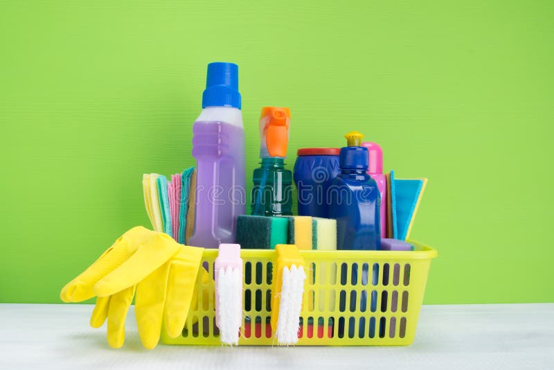 Na tabela, em um fundo verde é uma cesta com um grupo de ferramentas para a desinfecção e a limpeza imagens de stock royalty free Na tabela, em um fundo verde é uma cesta com um grupo de ferramentas para a desinfecção e a limpeza imagens de stock royalty free