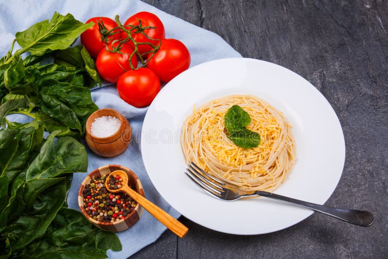 Na tabela é a parcela com massa, tomates, verdes e especiarias imagens de stock royalty free Na tabela é a parcela com massa, tomates, verdes e especiarias imagens de stock royalty free