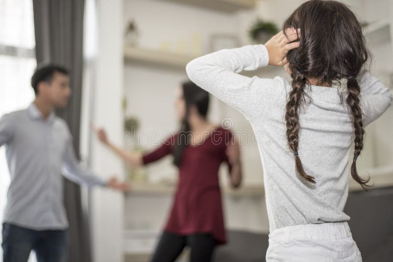 Na vista traseira, a menina p?e suas m?os sobre suas orelhas porque n?o quer ouvir sua discuss?o do paizinho e da mam? orelhas pr fotografia de stock royalty free Na vista traseira, a menina p?e suas m?os sobre suas orelhas porque n?o quer ouvir sua discuss?o do paizinho e da mam? orelhas pr fotografia de stock royalty free