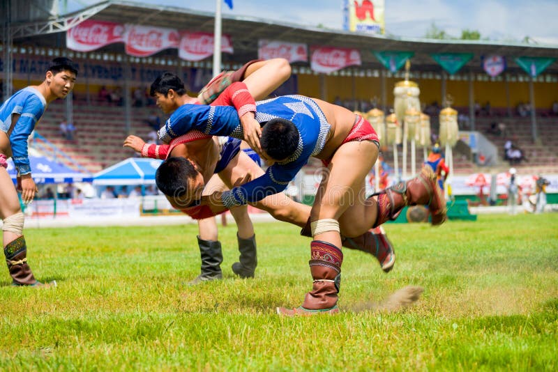 Ulaanbaatar, Mongolia - June 11, 2007: A teenage wrestler throwing his opponent mid-air to the ground inside the National Sports Stadium at a Naadam Festival wrestling match. Ulaanbaatar, Mongolia - June 11, 2007: A teenage wrestler throwing his opponent mid-air to the ground inside the National Sports Stadium at a Naadam Festival wrestling match