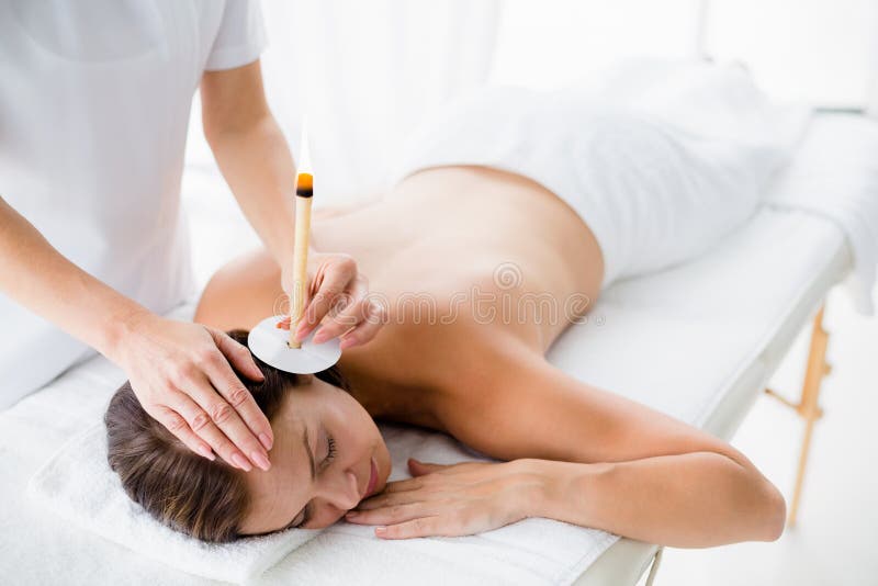 Naakte vrouw die de behandeling van de oorkaars van masseur ontvangen royalty-vrije stock afbeelding Naakte vrouw die de behandeling van de oorkaars van masseur ontvangen royalty-vrije stock afbeelding