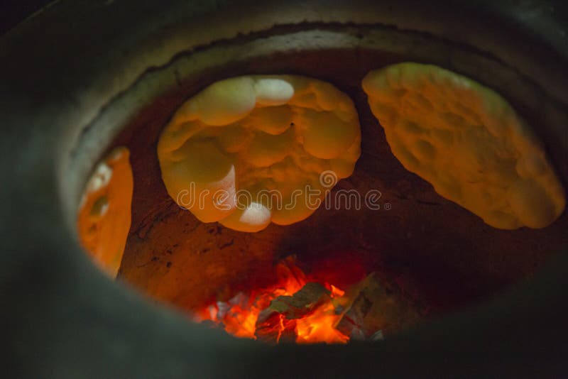 A fire on tandoori oven with naan bread inside. A fire on tandoori oven with naan bread inside