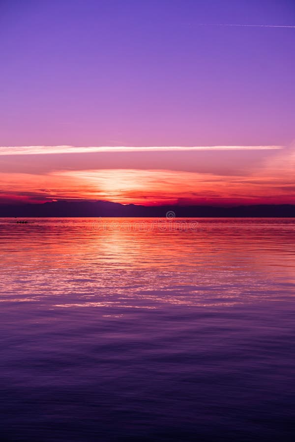 Nach Sonnenuntergang-Farben durch das Meer, purpurrote Töne stockbild Nach Sonnenuntergang-Farben durch das Meer, purpurrote Töne stockbild