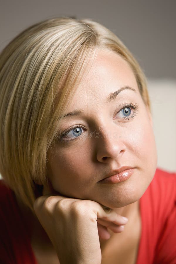 Portrait of a young woman looking pensively into the distance. Vertical shot. Portrait of a young woman looking pensively into the distance. Vertical shot.