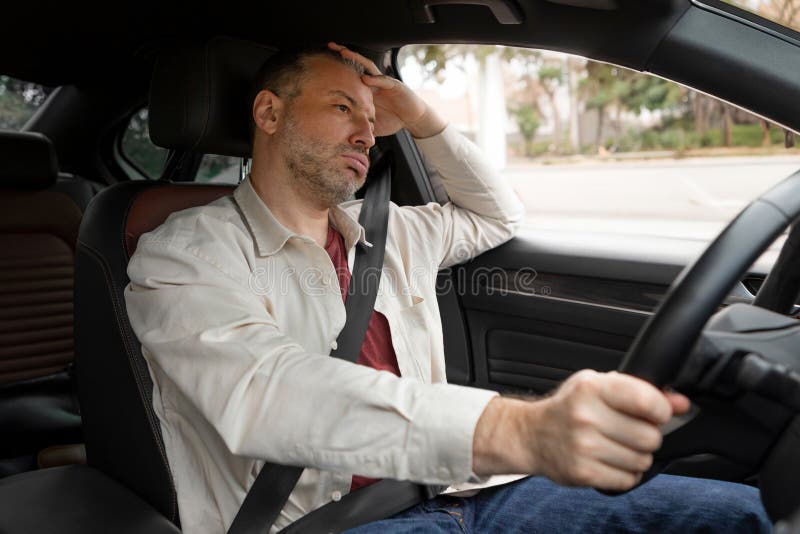Nachdenklicher müder Fahrer, der Auto fährt, sitzt im fahrenden männlichen Fahrer fest, der den Sicherheitsgurt anschnallt und dab stockfotos