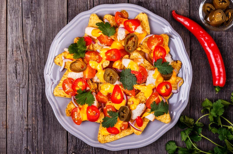 Nacho con la salsa di formaggio, il jalapeno, il pollo e la verdura fusi immagine stock libera da diritti Nacho con la salsa di formaggio, il jalapeno, il pollo e la verdura fusi immagine stock libera da diritti