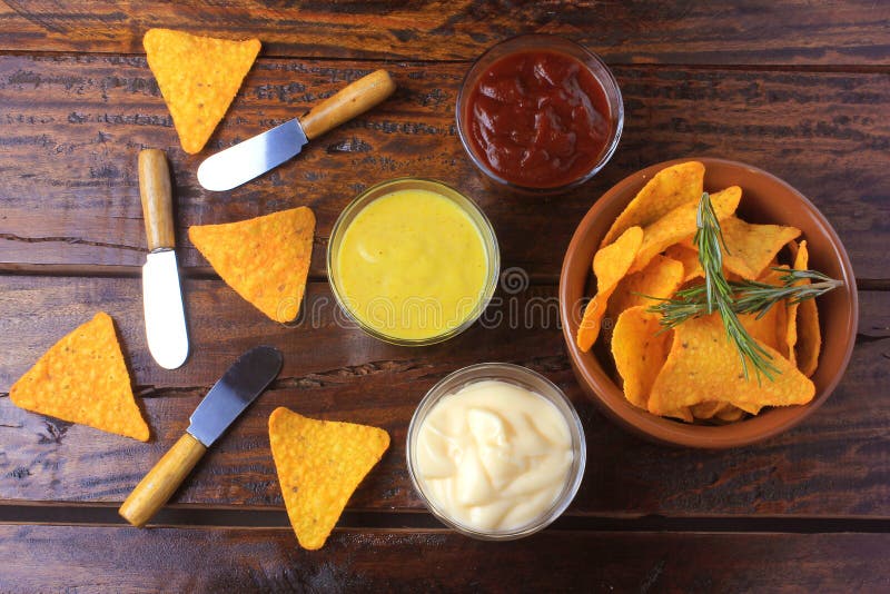 Nachos konserverar chiper som förläggas i keramisk bunke på trätabellen bredvid blandade såser Top beskådar fotografering för bildbyråer Nachos konserverar chiper som förläggas i keramisk bunke på trätabellen bredvid blandade såser Top beskådar fotografering för bildbyråer