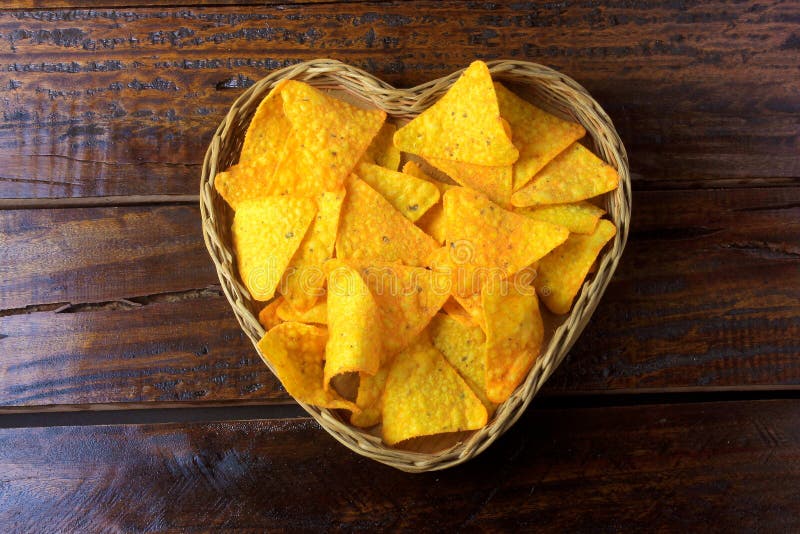 Nachos konserverar chiper som förläggas i korg med hjärtaform på trätabellen, utrymme för text Top beskådar arkivfoton Nachos konserverar chiper som förläggas i korg med hjärtaform på trätabellen, utrymme för text Top beskådar arkivfoton