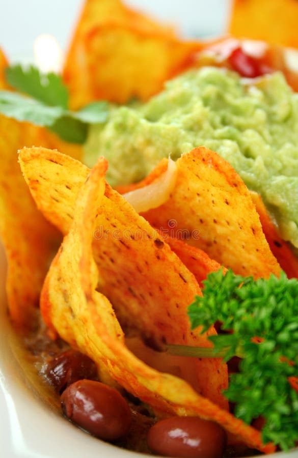 Delicious vegetarian nachos with guacamole, tomato salsa and sour cream. Delicious vegetarian nachos with guacamole, tomato salsa and sour cream.