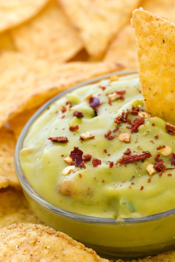 Nachos with a avocado dip as closeup on white background. Nachos with a avocado dip as closeup on white background