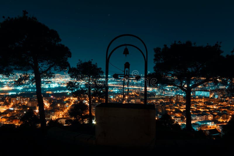 Nachtmening van over hoofdstad van Georgië, Tbilisi Straatlantaarns en heuvels die de stad omringen Blauw hemel en kerkkruis op b stock afbeelding Nachtmening van over hoofdstad van Georgië, Tbilisi Straatlantaarns en heuvels die de stad omringen Blauw hemel en kerkkruis op b stock afbeelding