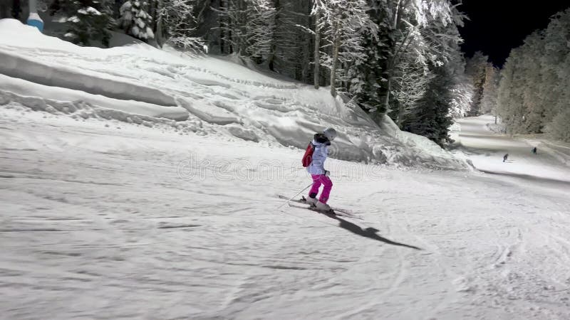 Nachtskiën op de skipiste met gevroren bomen in de winter