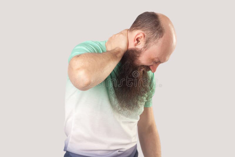 Nackenschmerzen Portrait eines kranken Glatschmänners mittleren Alters mit langem Bart in hellgrünem T-Shirt, das seinen schmerzh