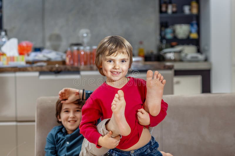 Nackte Kinderfüße auf der Couch beim Spielen lizenzfreie stockbilder