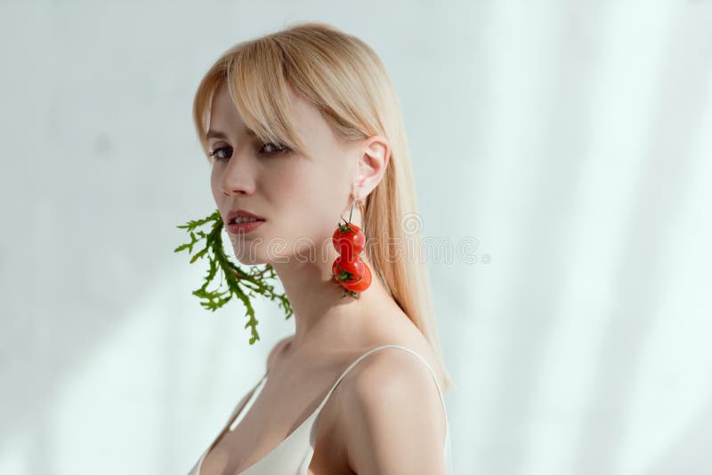 nadenkende die vrouw in kleding met oorringen van verse arugula en kersentomatenveganist worden gemaakt stock fotografie nadenkende die vrouw in kleding met oorringen van verse arugula en kersentomatenveganist worden gemaakt stock fotografie