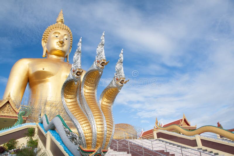 Naga och stor guld- buddha staty under konstruktion i thailändsk tempel med klar himmel WAT MUANG, Ang Thong, THAILAND arkivfoton Naga och stor guld- buddha staty under konstruktion i thailändsk tempel med klar himmel WAT MUANG, Ang Thong, THAILAND arkivfoton