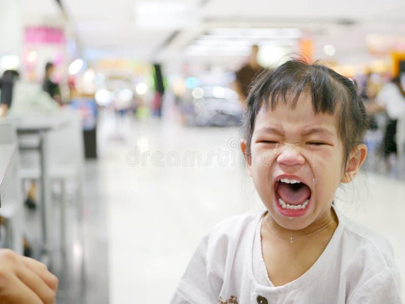 A sudden uncontrollable burst of crying of an Asian baby girl in a shopping mall - baby behavior. A sudden uncontrollable burst of crying of an Asian baby girl in a shopping mall - baby behavior