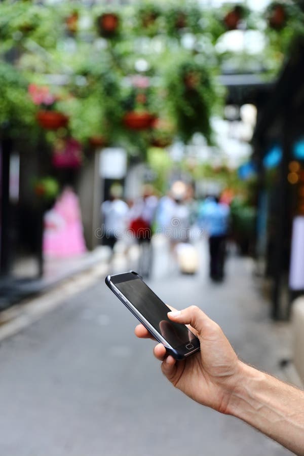 Nahaufnahme der Hand unter Verwendung des Smartphone in der Stadtstraße lizenzfreie stockbilder Nahaufnahme der Hand unter Verwendung des Smartphone in der Stadtstraße lizenzfreie stockbilder